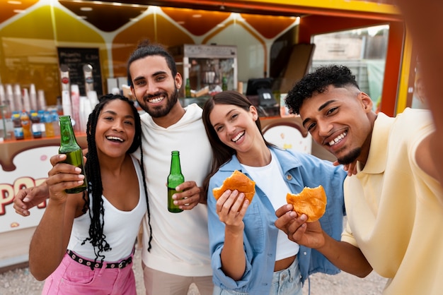 Foto amigos sorridentes de tiro médio tirando selfie