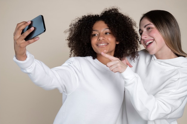 Amigos sorridentes de tiro médio tomando selfie