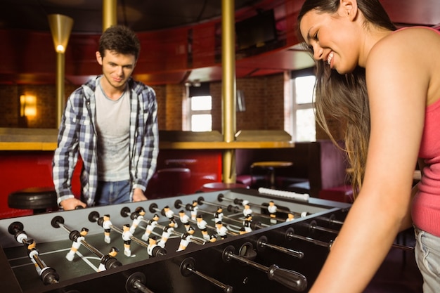 Foto amigos sorridentes jogando futebol de mesa