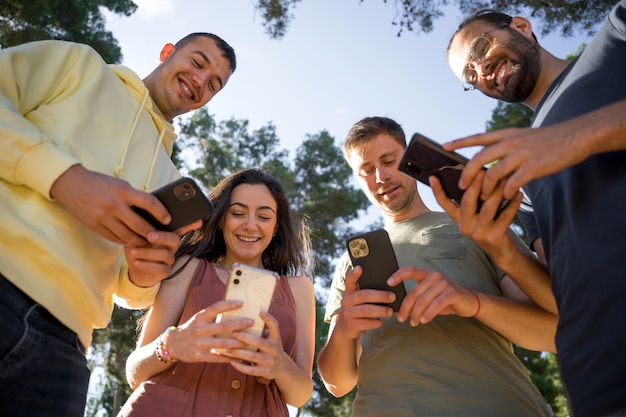 Amigos sorrindo com seus telefones celulares Cada um com seu celular Imagens de close