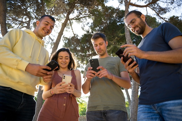 Amigos sorrindo com seus telefones celulares Cada um com seu celular Imagens de close