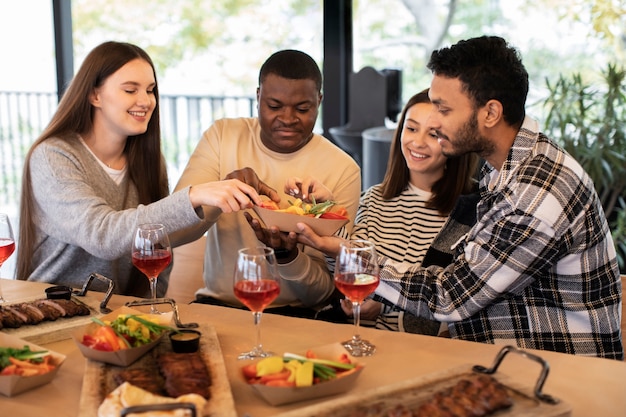 Amigos sorrindo e tirando frutas de uma tigela