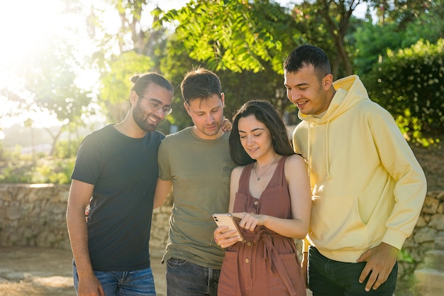 Amigos sorrindo enquanto olham para um telefone celular Eles estão juntos olhando para o mesmo telefone celular