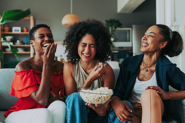 Amigos sorrindo usando smartphone enquanto estão sentados em casa