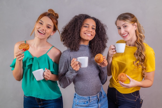 Amigos en el té de la tarde comiendo donas y bebiendo café con leche