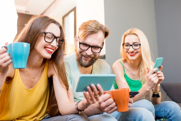 Amigos con teléfonos en casa