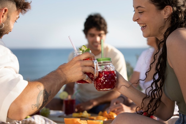 Foto amigos tendo uma festa de sangria na praia