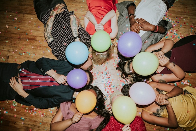 Amigos tirados en el suelo en una fiesta con globos