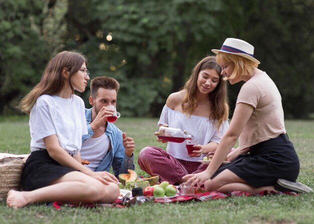 Amigos de tiro completo bebiendo jugo al aire libre