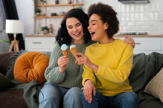 Amigos de tiro medio comiendo un sabroso helado.