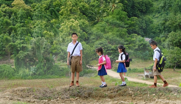 Amigos de toda la longitud en uniforme escolar en el campo