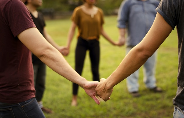 Foto amigos de todas las edades tomados de la mano.