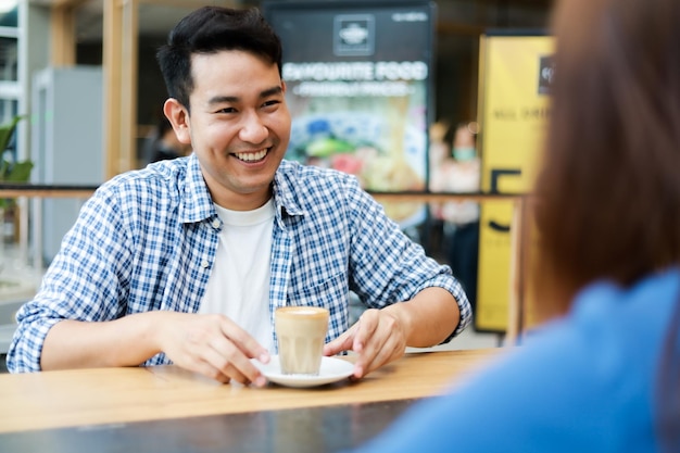 Amigos tomando café mientras hablan en la cafetería