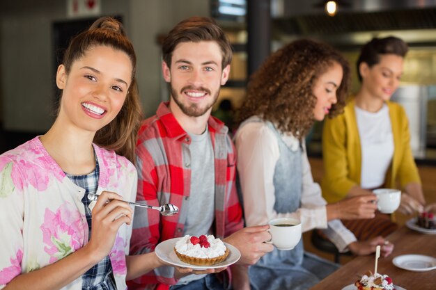 Amigos tomando café y postre en la cafetería