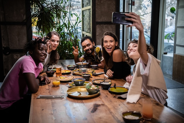 Foto amigos tomando selfies en un café durante una cena