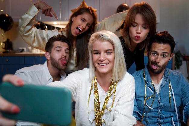 Foto amigos tomando selfies en la fiesta