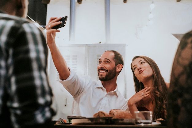 Amigos tomando uma selfie em um jantar