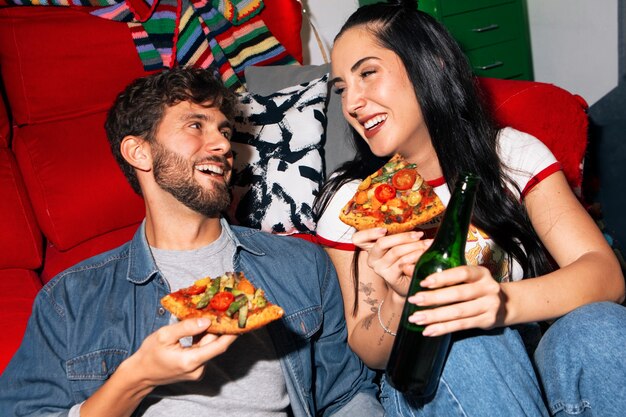 Amigos de tomas medianas comiendo pizza