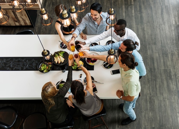 Amigos tostan un vaso de jugo juntos en el restaurante