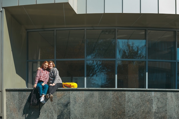 Los amigos de la universidad toman un descanso después de las clases abrazándose