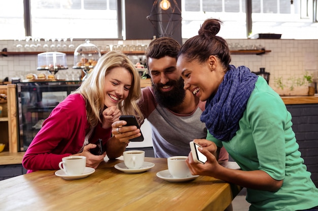 Amigos usando smartphones sentado