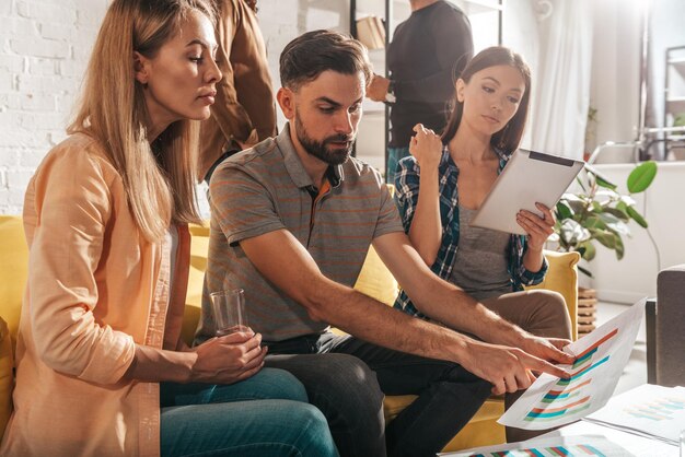 Foto amigos usando tablet digital enquanto estão sentados em casa