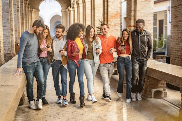 Amigos usando telefone celular enquanto caminham no corredor