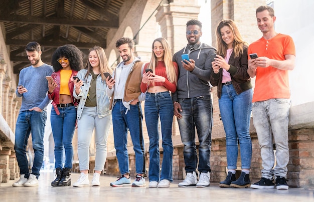Amigos usando telefones enquanto estão de pé no corredor