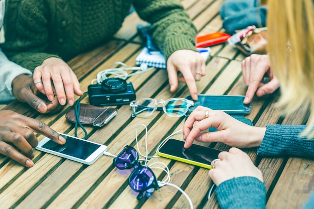 Amigos usando teléfonos en la mesa