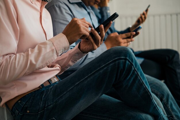 Foto amigos usando teléfonos móviles mientras están sentados