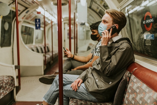 Amigos usando um smartphone em um trem no novo normal