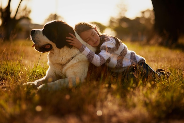 Amigos vêm em todas as formas e tamanhos Foto de uma garotinha fofa abraçando seu cachorro enquanto brincam lá fora