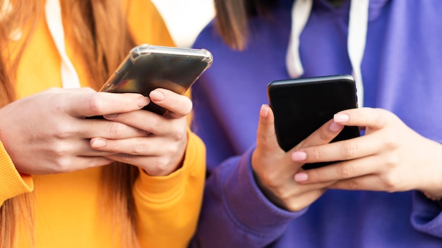 Foto amigos verificando seus telefones ao ar livre