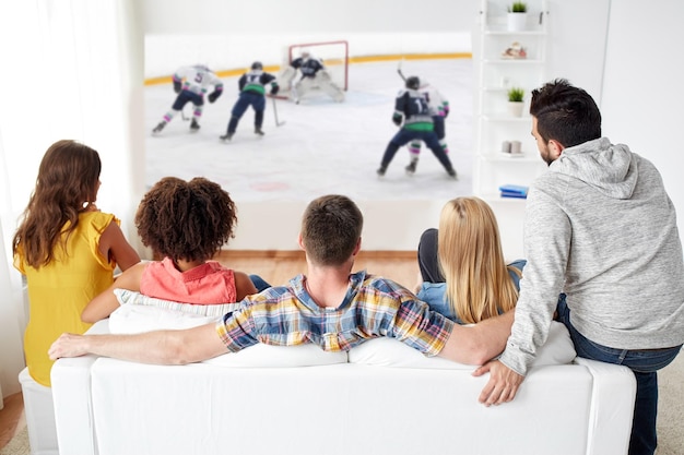 amigos viendo hockey sobre hielo en la pantalla del proyector