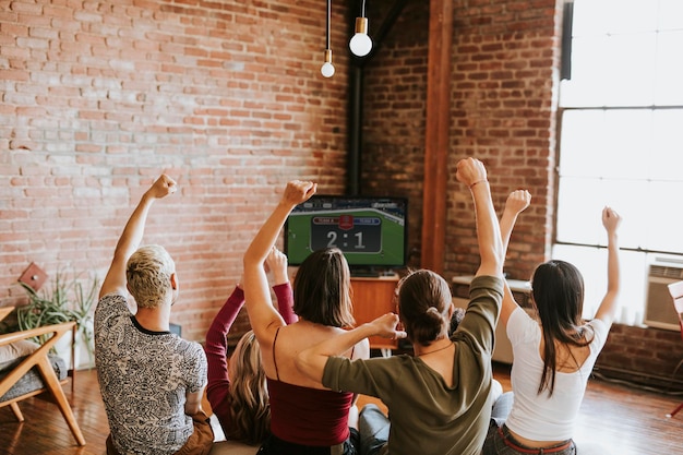 Amigos viendo un programa de juegos en la televisión