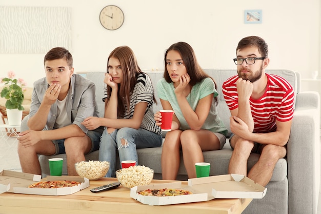 Amigos viendo la televisión en casa