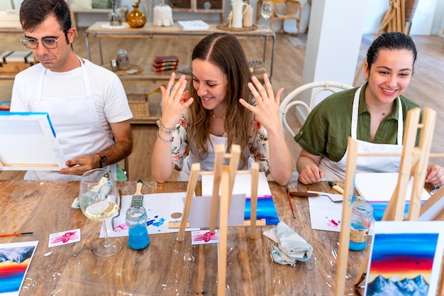 Amigos del vino y la pintura disfrutando juntos de un taller de arte