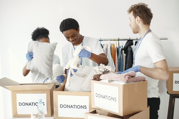 Amigos voluntários empilham caixas. Inspeção da ajuda humanitária. Doações para os pobres.