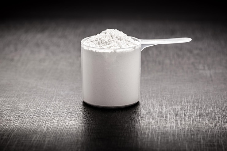 Foto aminosäuren-ergänzung für sportliche zwecke, kreatin in einem messlöffel, hmb, bcaa, aminosäure oder vitaminpulver. sporternährungskonzept