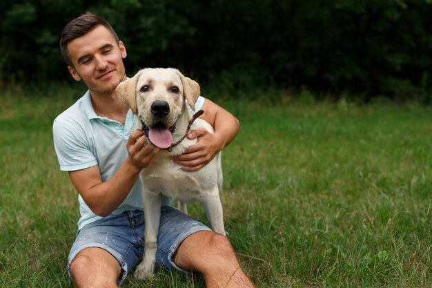 Foto la amistad del hombre y el perro. feliz joven está jugando con su amigo