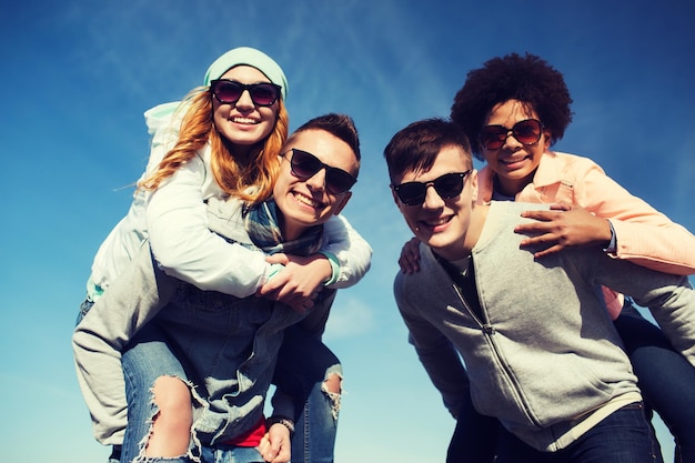 amistad, ocio, internacional y concepto de personas - grupo de amigos adolescentes felices con gafas de sol divirtiéndose al aire libre