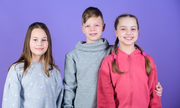 Foto amistad verdadera de niña y niño niños caras sonrientes sobre fondo violeta abrazo de amigos día del niño juventud alegre relaciones y amistad feliz de tener tan buenos amigos amigos adolescentes