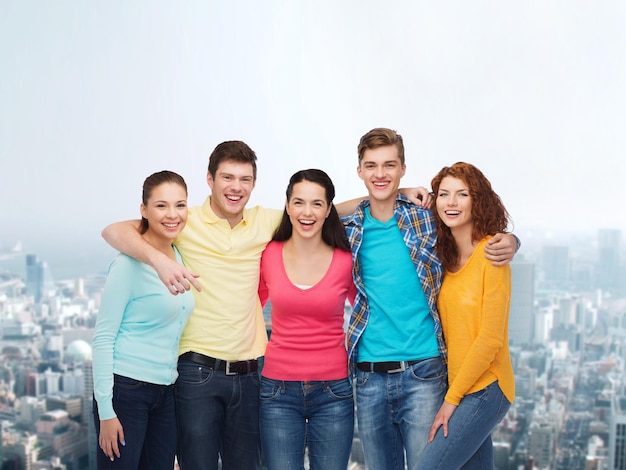 amistad, vida en la ciudad y concepto de la gente - grupo de adolescentes sonrientes sobre el fondo de la ciudad