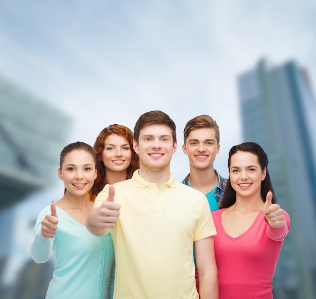 amistad, vida en la ciudad, concepto de negocios y personas - grupo de adolescentes sonrientes sobre el fondo de la ciudad