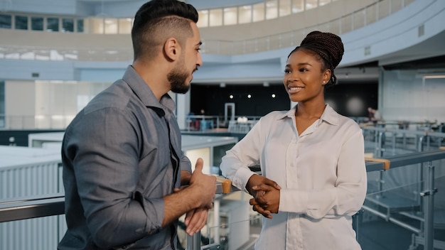 Amistosos socios comerciales multiétnicos colegas mujer africana y hombre árabe indio hablando