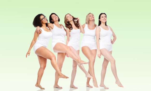amizade, beleza, corpo positivo e conceito de pessoas - grupo de mulheres felizes diferentes em cueca branca sobre fundo verde natural