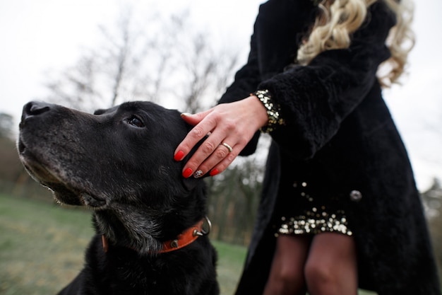 Amizade cão e homem. amante em uma caminhada com um cão preto raça labrador na natureza.