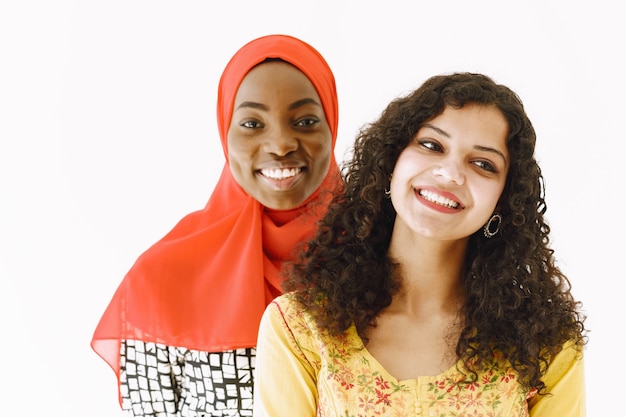 Amizade com as nações. mulheres africanas e indianas com roupas tradicionais. estúdio branco e isolado.