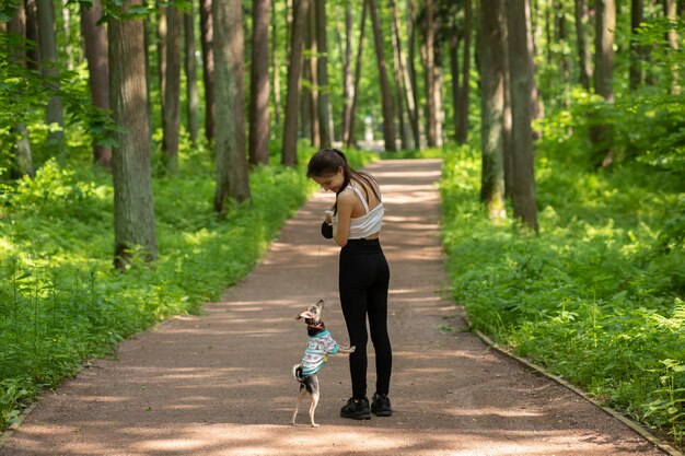 Amizade com um animal de estimação. Um cachorro fofo com um dono parado em um parque