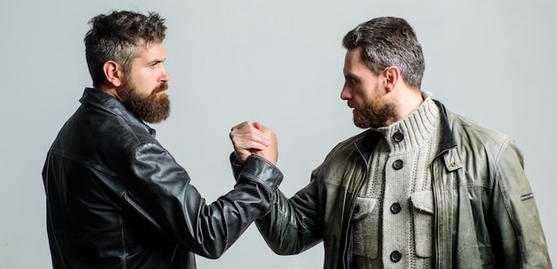 Foto amizade de caras brutais conceito de liderança amizade verdadeira de amigos maduros amizade masculina homens barbudos brutais usam jaquetas de couro apertando as mãos homens reais e fraternidade aperto de mão forte